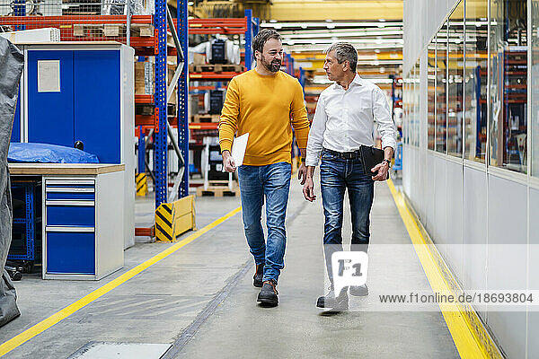 Businessmen walking together in factory