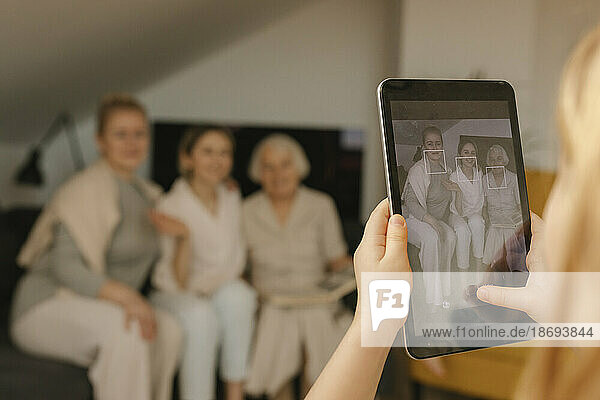 Mädchen fotografiert Familie zu Hause mit Tablet-PC