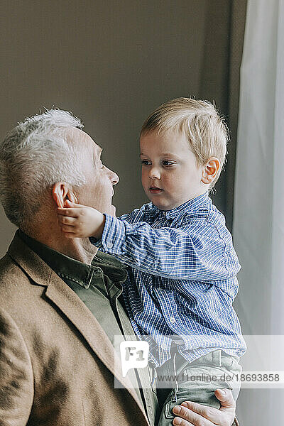 Großvater trägt Enkel zu Hause