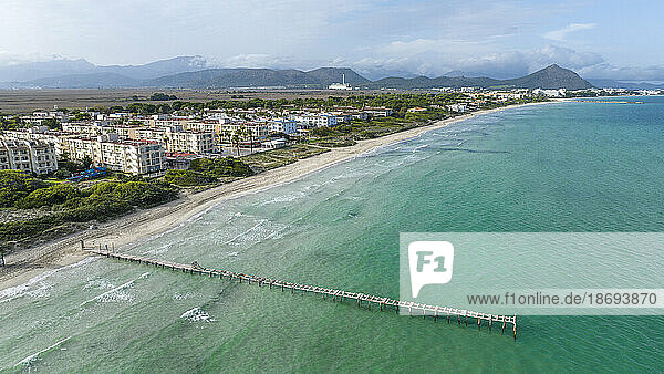 Spain  Balearic Islands  Can Picafort  Aerial view of coastal town with pier in foreground