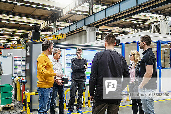 Manager and businessman planning with employees at factory