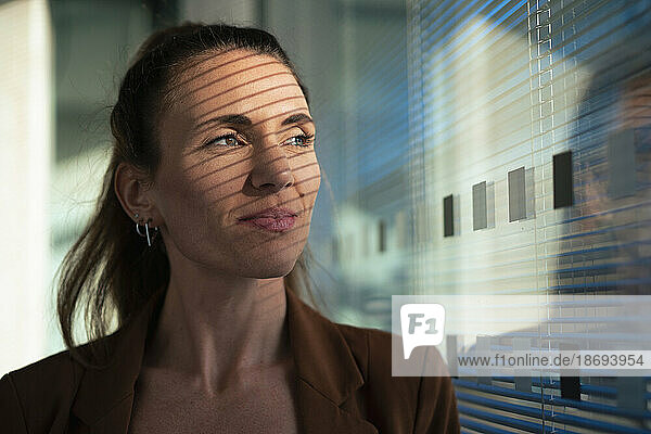 Thoughtful businesswoman near wall at office