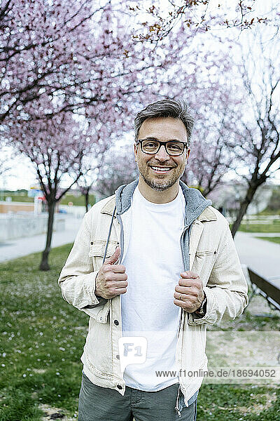 Smiling man wearing eyeglasses standing at park