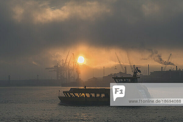 Germany  Hamburg  Sun rising over harbor ferry