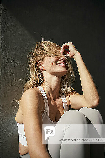 Blonde junge Frau lacht im Sonnenlicht