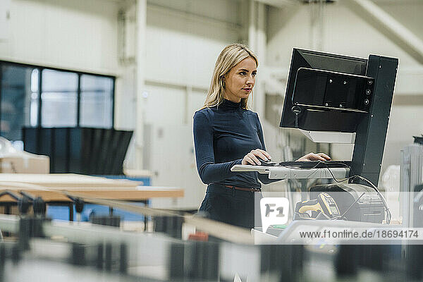 Businesswoman working on desktop PC in carpentry factory