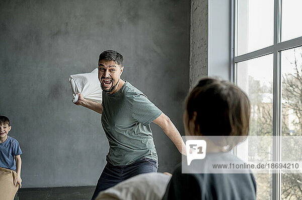 Father pillow fighting with son at home