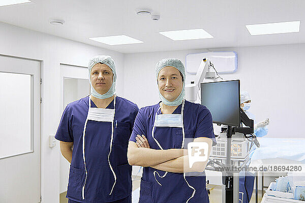 Confident surgeons standing in operating room