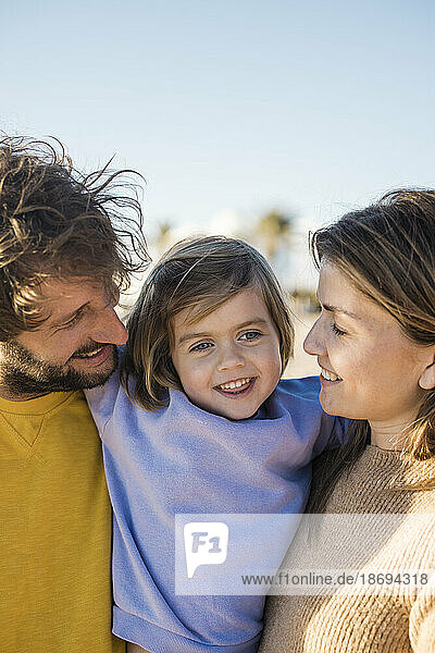 Father and mother enjoying vacations with daughter at beach