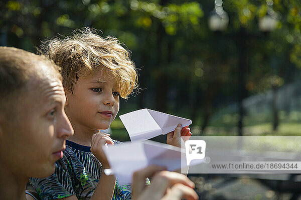 Sohn und Vater spielen mit Papierflieger