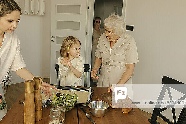 Mehrgenerationenfamilie bereitet zu Hause Essen zu