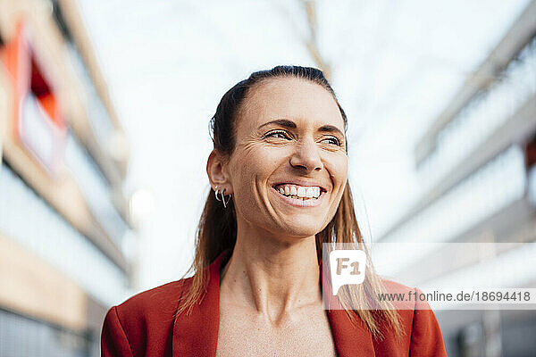 Contemplative businesswoman with toothy smile