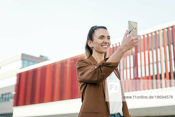 Happy businesswoman taking selfie through smart phone