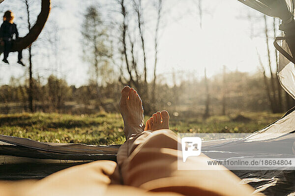 Frau entspannt sich an sonnigem Tag im Zelt