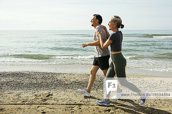 Happy couple running and having fun at beach