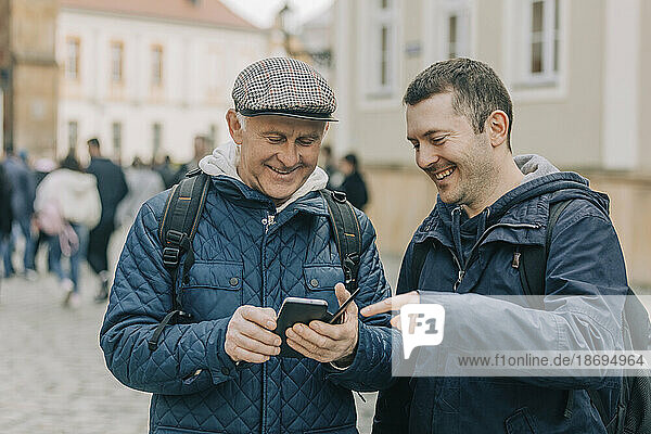 Älterer Tourist fragt Passanten auf der Straße telefonisch nach dem Weg