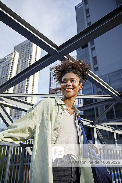 Smiling woman standing by railing