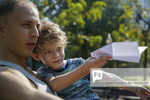 Vater und Sohn spielen mit Papierflieger