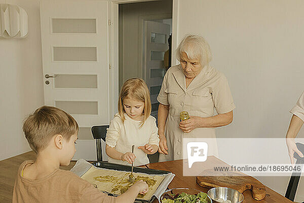Familie mit mehreren Generationen bereitet zu Hause Essen zu