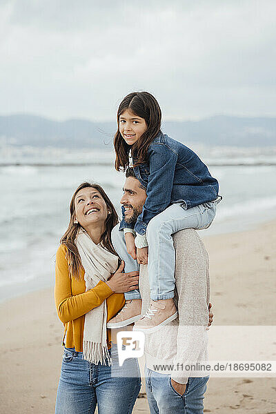 Glückliche Frau mit Familie  die am Strand genießt