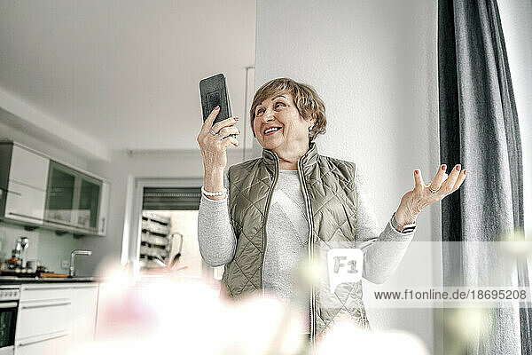 Ältere Frau führt zu Hause Videoanrufe über ihr Smartphone durch