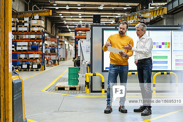 Mature businessman gesturing and having discussion in industry