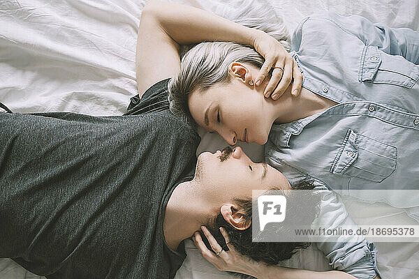 Mann und Frau liegen auf dem Bett und umarmen sich