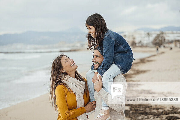 Happy woman with family enjoying vacations at beach
