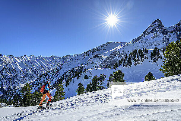 Österreich  Tirol  Sonne scheint über einer Skifahrerin am Torhelm
