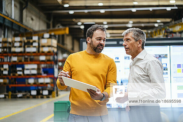 Mature businessmen having discussion together in factory