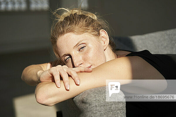 Woman resting on sofa in sunshine