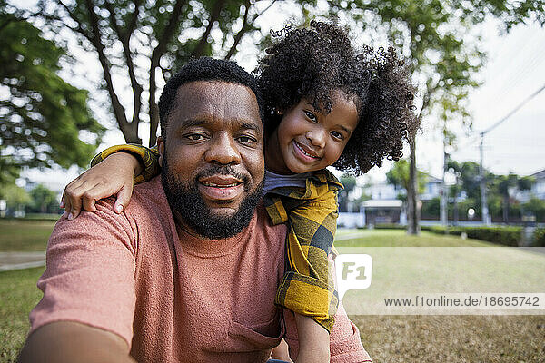 Smiling girl with father at park