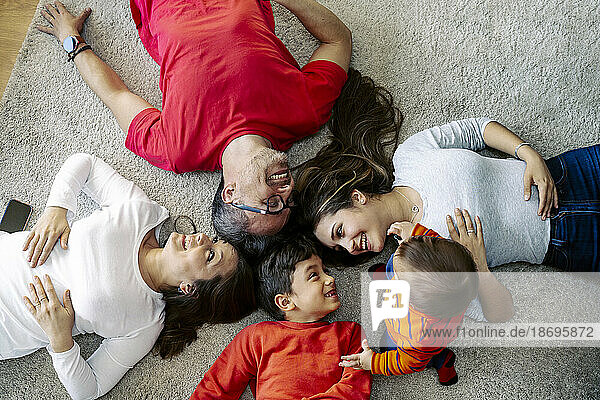 Happy family lying down on carpet at home