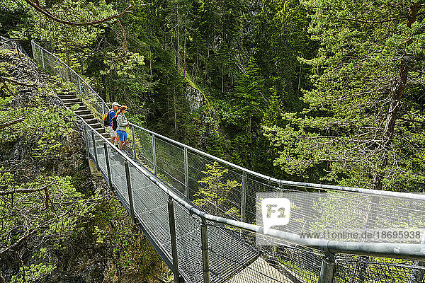 Austria  Tyrol  Hikers standing on bridge over Salvesenklamm canyon