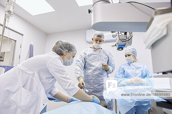 Arzt und Krankenschwester bereiten sich im Operationssaal auf eine Augenoperation vor