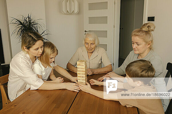 Multi-generation family playing game on table at home