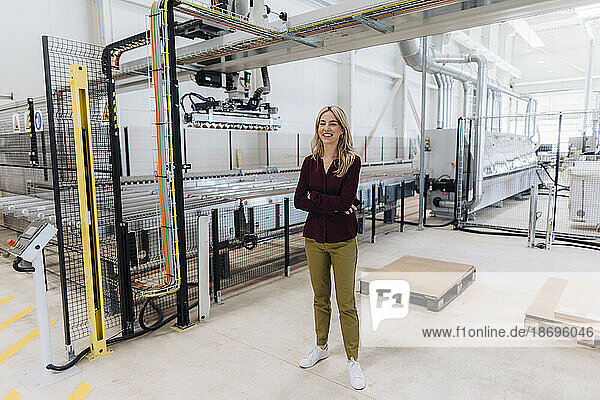 Smiling businesswoman standing in in factory