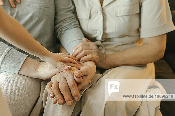 Family stacking hands sitting at home