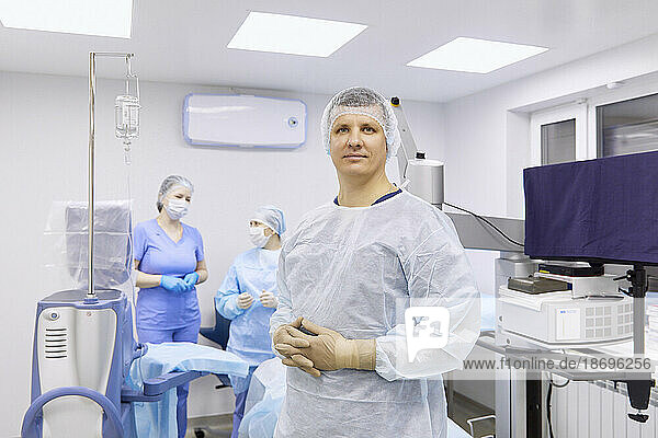 Surgeon with colleagues in illuminated operating room