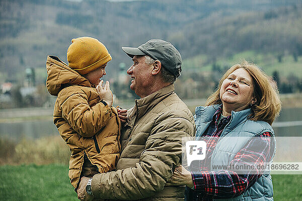 Grandparents having fun with grandson wearing warm clothing