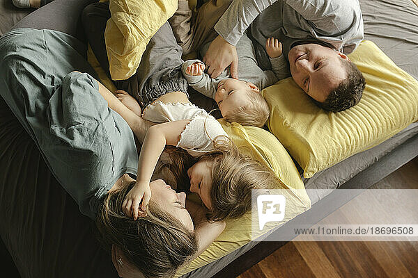 Family lying together on bed at home
