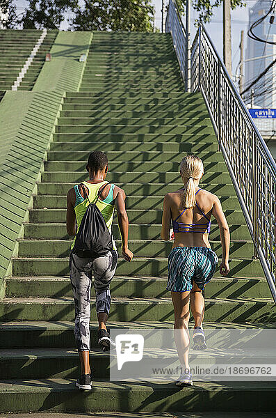 Multiracial women exercising on stairs at sunny day