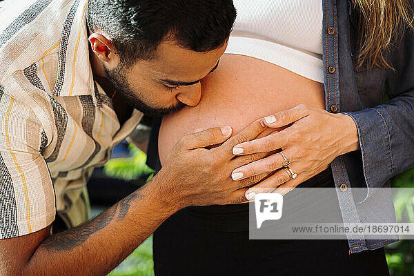 Man kissing belly of pregnant woman
