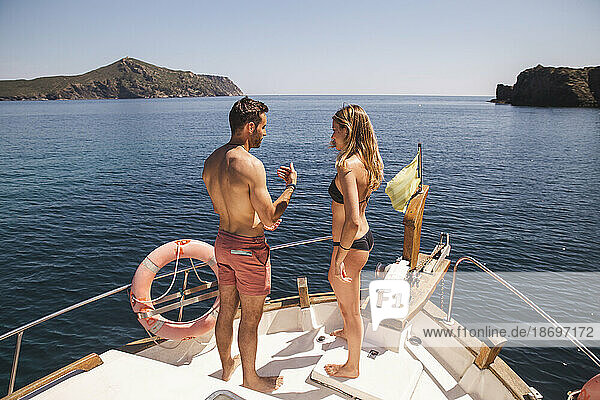 Man talking to woman wearing bikini on boat