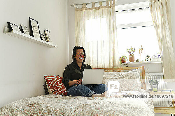 Happy freelancer working on laptop at home office
