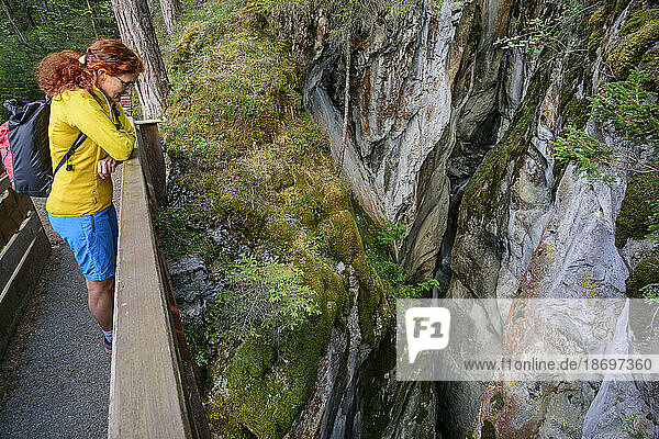 Austria  Tyrol  Kronburg  Female hiker looking down at canyon