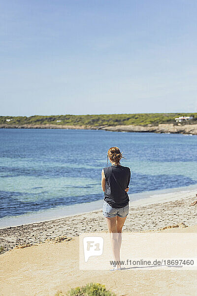 Spain  Balearic Islands  Formentera  Woman standing alone on Mediterranean beach