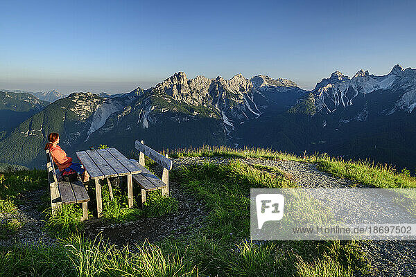 Italy  Province of Belluno  Female hiker sitting at mountaintop table at Monte Punta