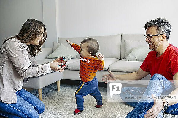 Father and mother playing with son in living room at home