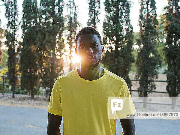 Athlete wearing yellow t-shirt in front of trees